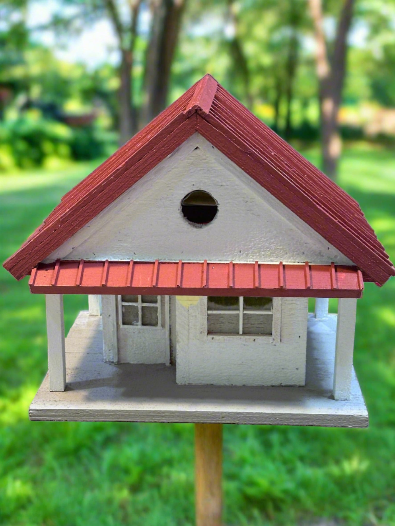 Welcome to the "Tin Can Alley" Birdhouse - a rustic farmhouse style birdhouse reminiscent of old General Stores. Its faux metal roof adds a charming touch to any backyard and the clean-out hatch makes for easy maintenance. In vibrant red and white, it's sure to be a feathered friend favorite!