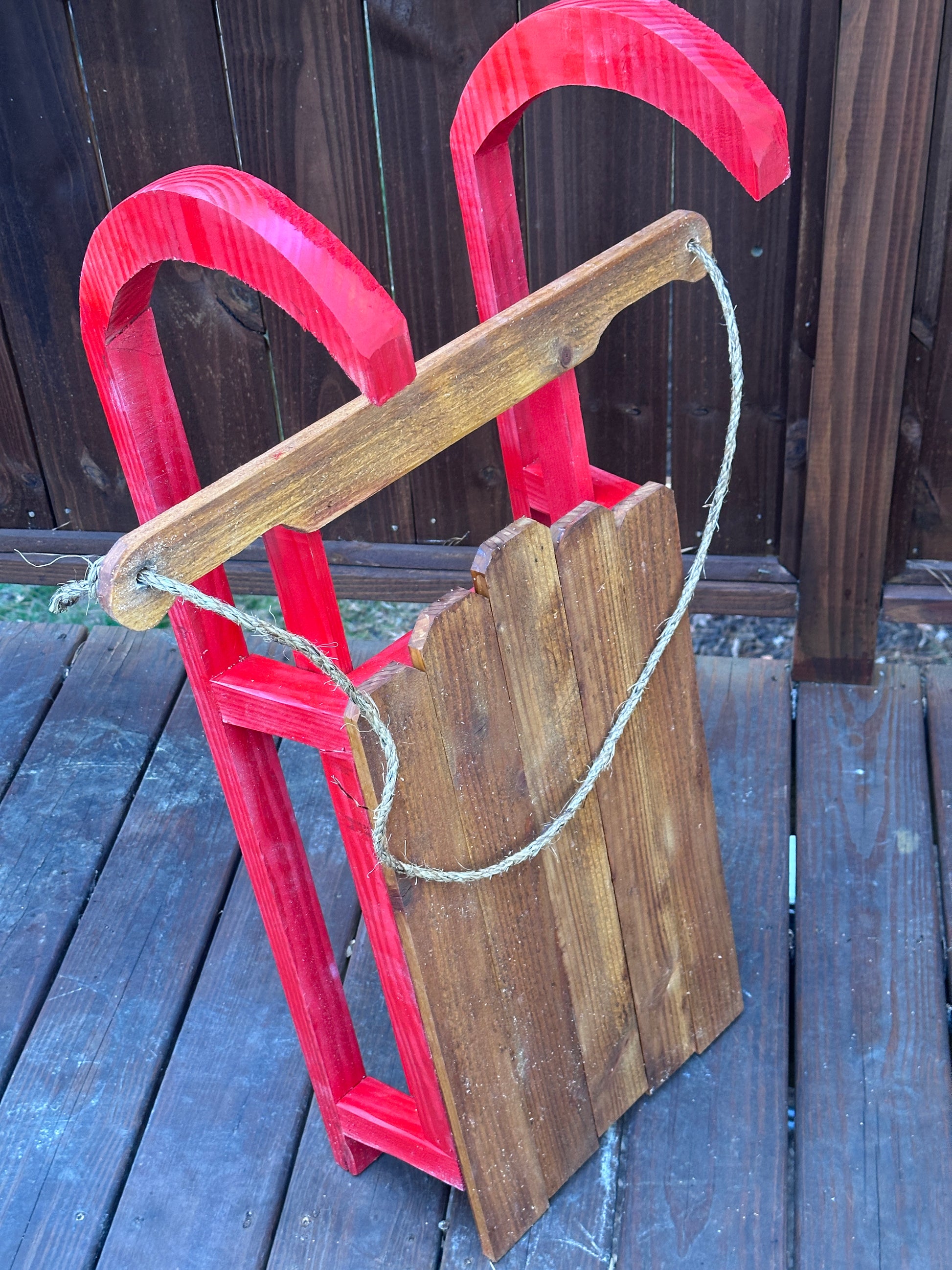 Red and wooden sled on a wooden surface