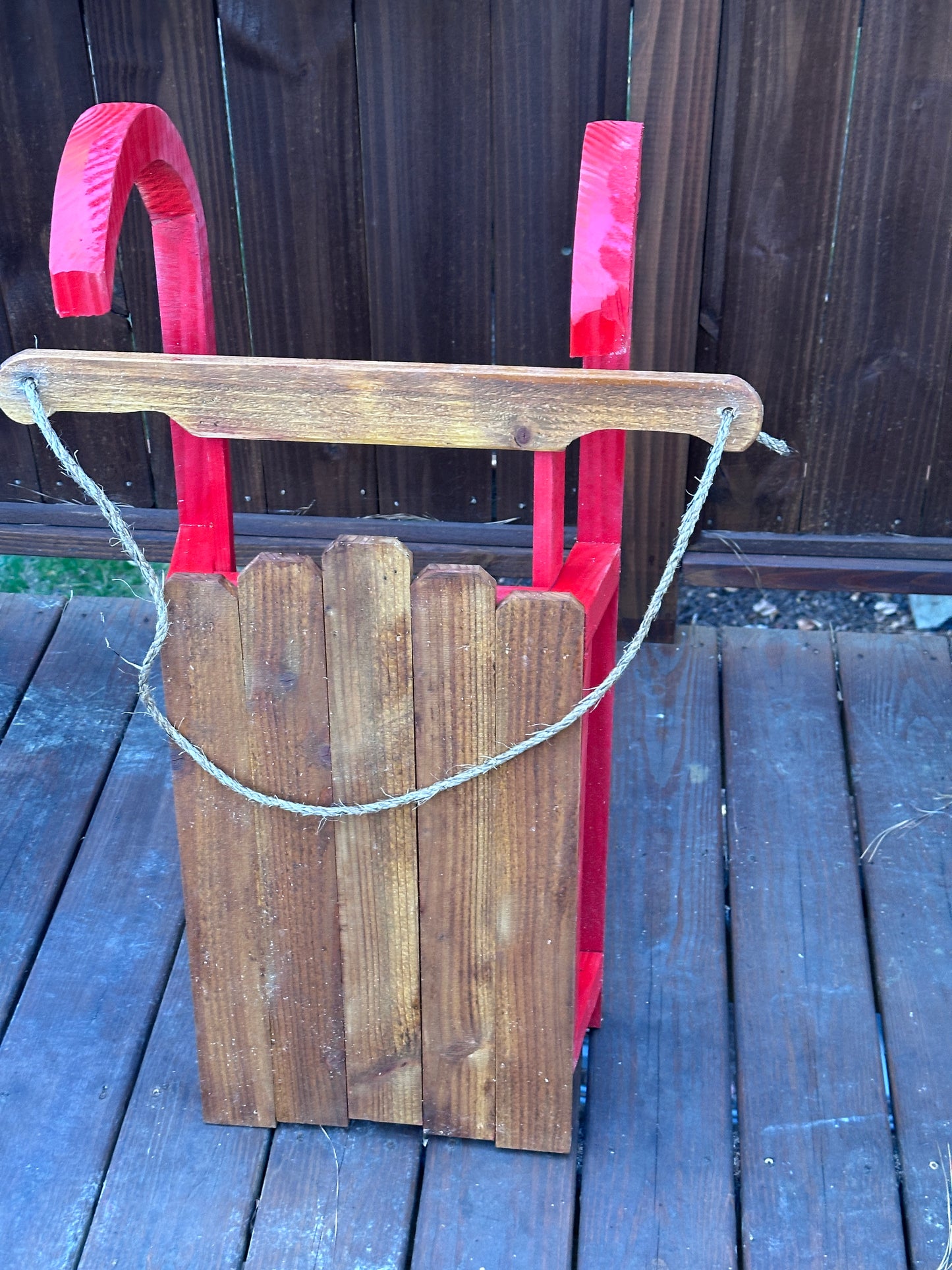 Wooden tool with a red handle on a wooden surface