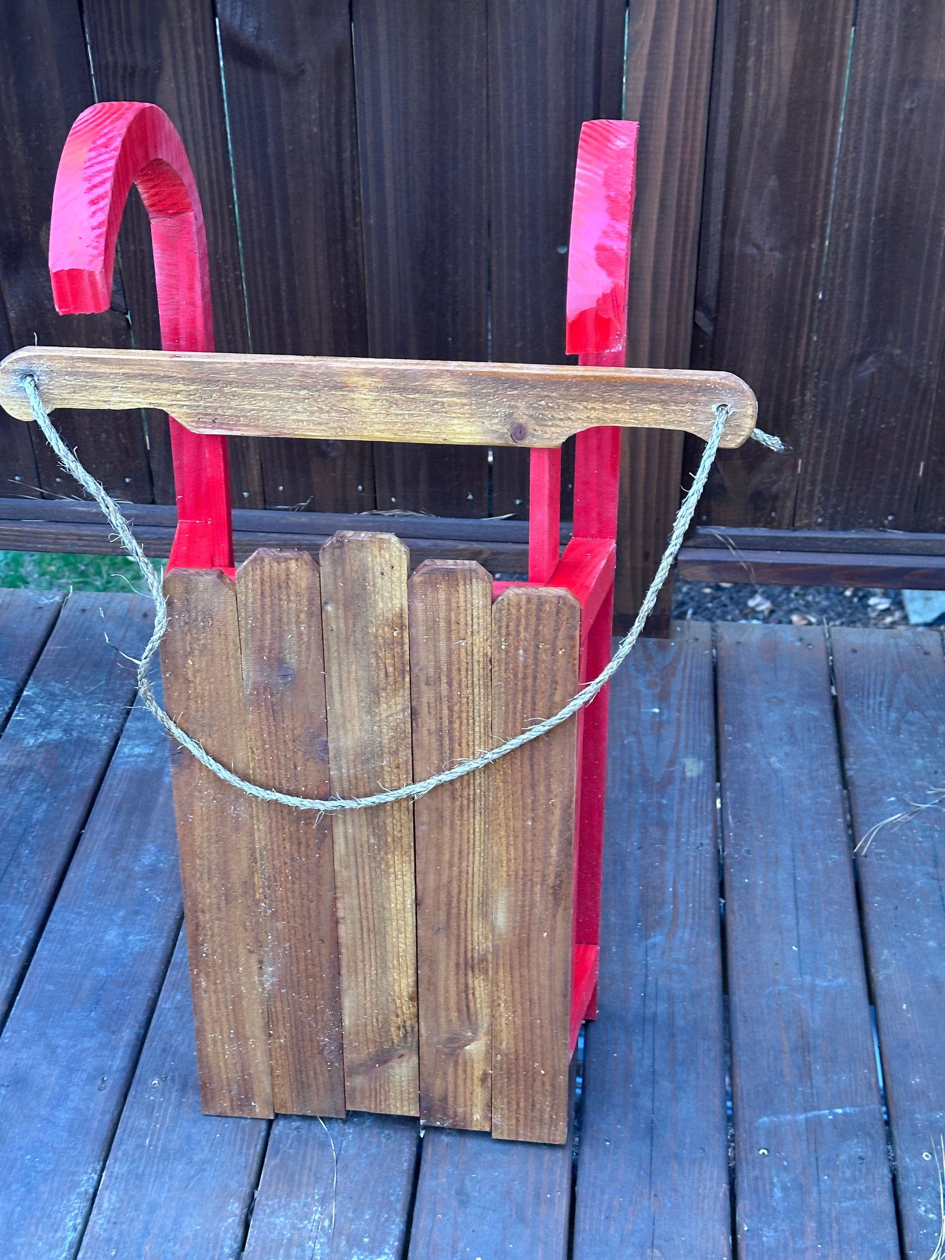 Wooden tool with a red handle on a wooden surface