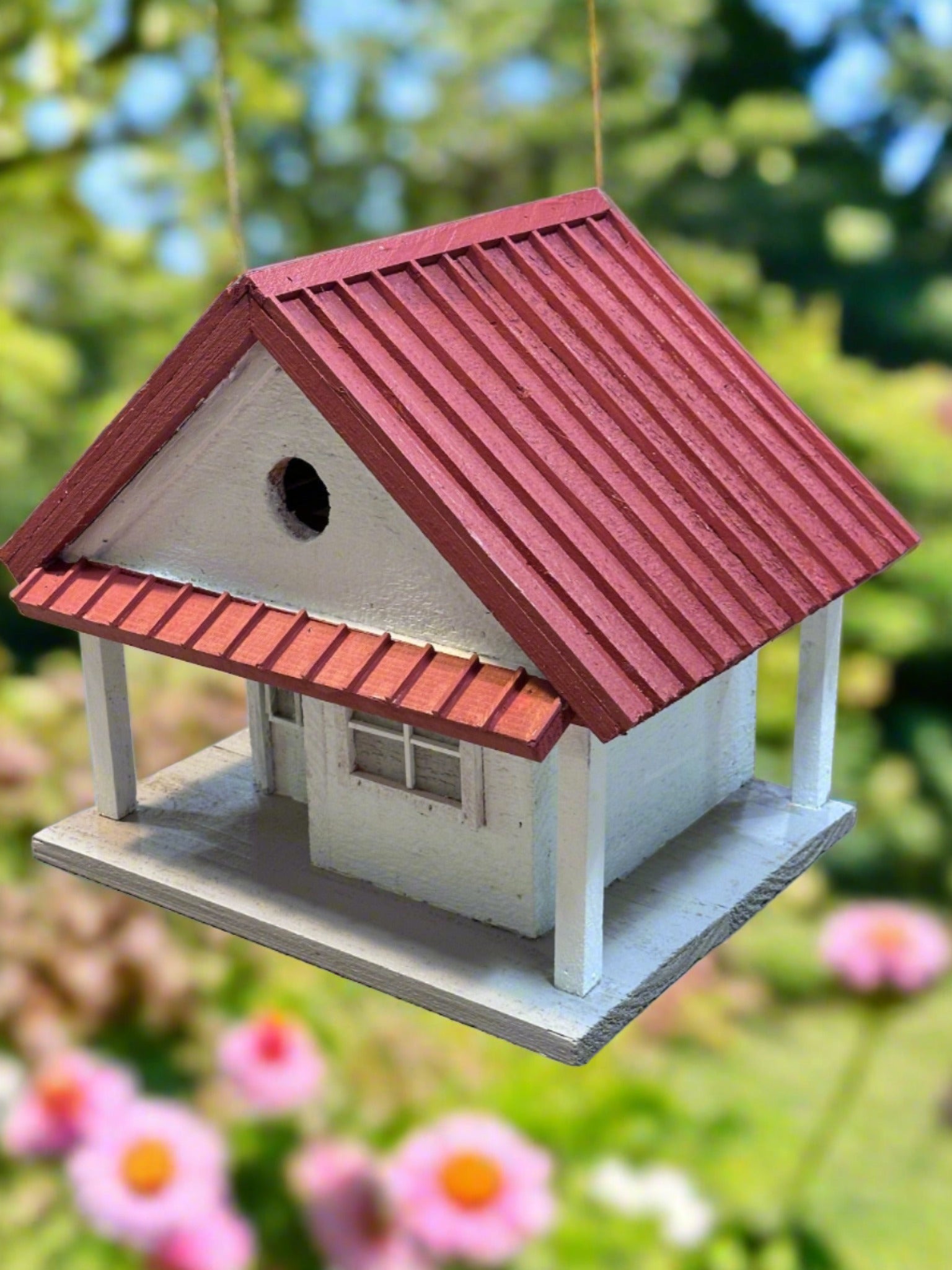 Welcome to the "Tin Can Alley" Birdhouse - a rustic farmhouse style birdhouse reminiscent of old General Stores. Its faux metal roof adds a charming touch to any backyard and the clean-out hatch makes for easy maintenance. In vibrant red and white, it's sure to be a feathered friend favorite!