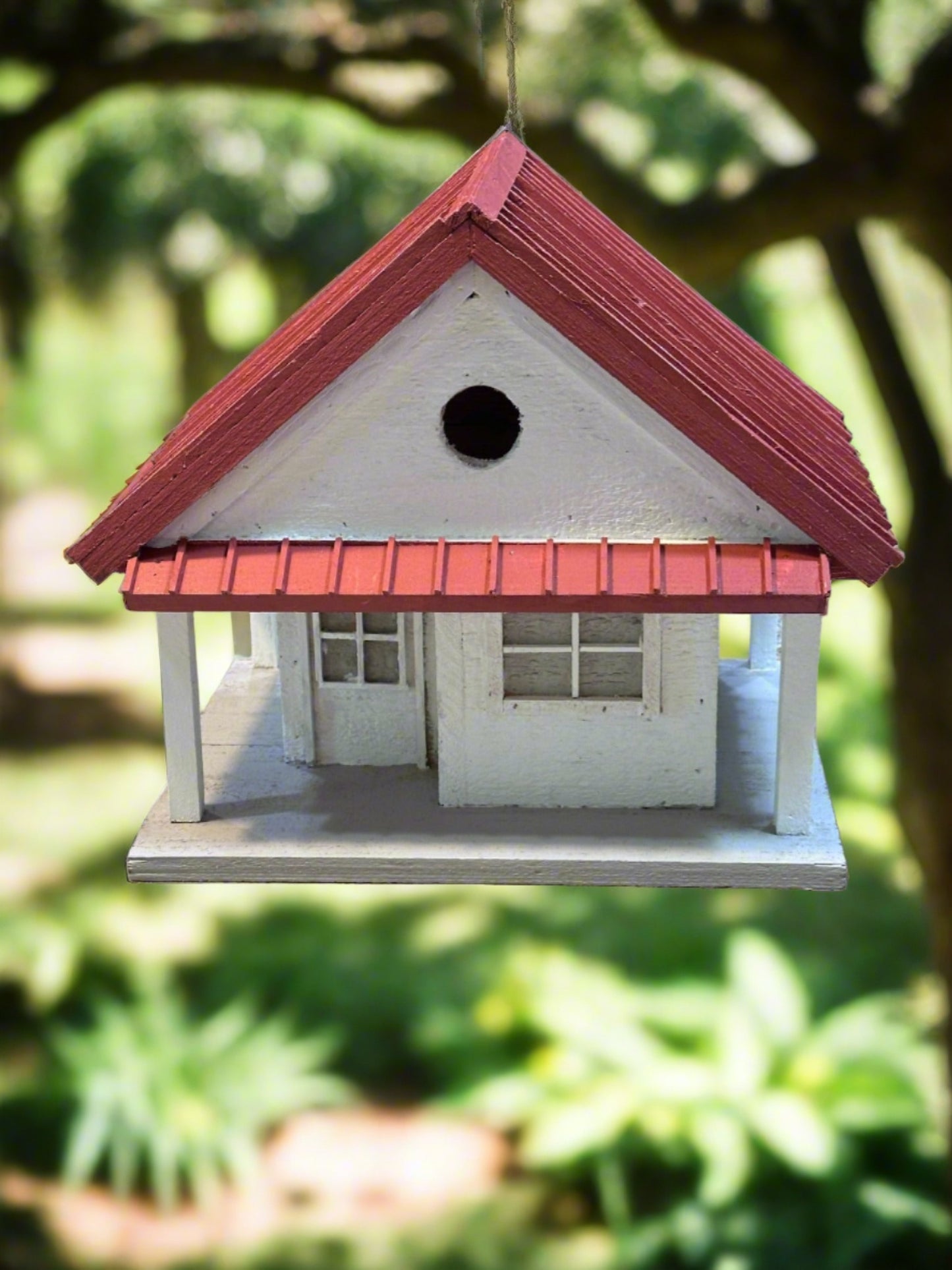 Welcome to the "Tin Can Alley" Birdhouse - a rustic farmhouse style birdhouse reminiscent of old General Stores. Its faux metal roof adds a charming touch to any backyard and the clean-out hatch makes for easy maintenance. In vibrant red and white, it's sure to be a feathered friend favorite!